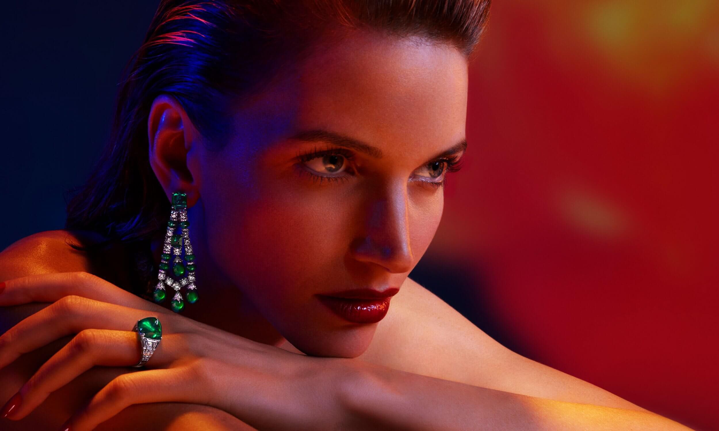 A model wears Graff high jewellery emerald and diamond earrings and am sugarloaf Colombian emerald ring.