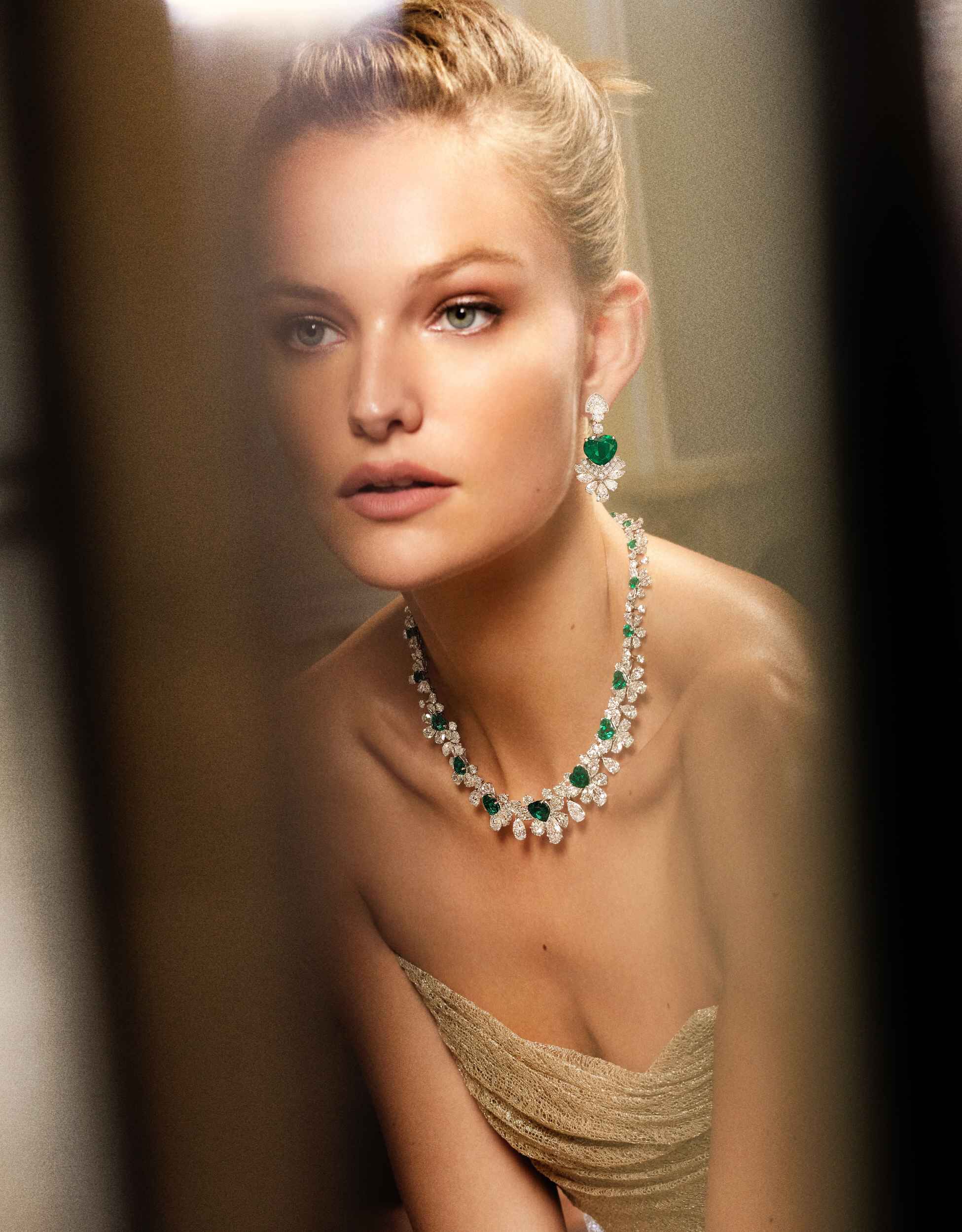 Close up of a woman wearing Graff emerald and white diamond high jewellery