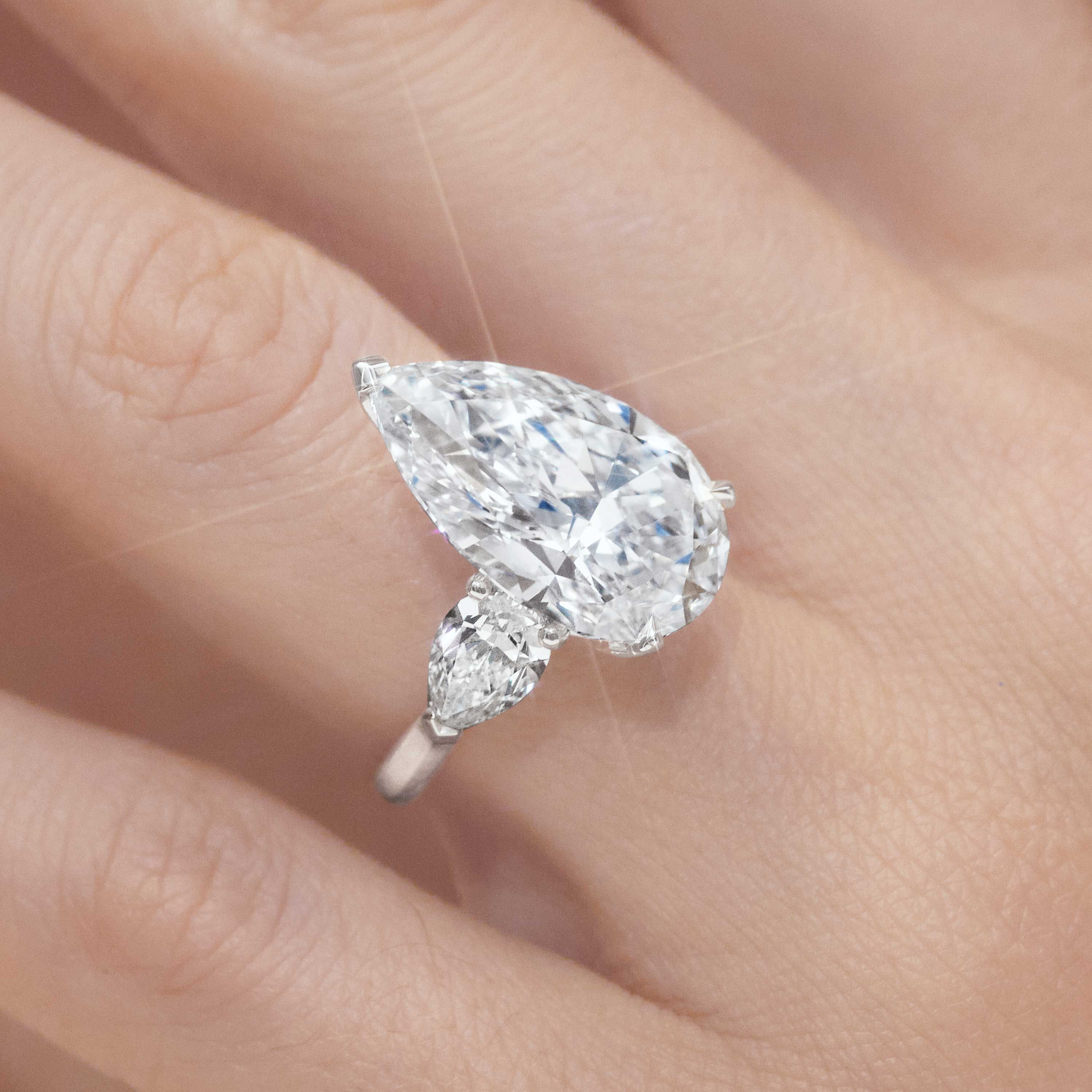 Close up of a Graff pear shape diamond engagement ring wore by a model