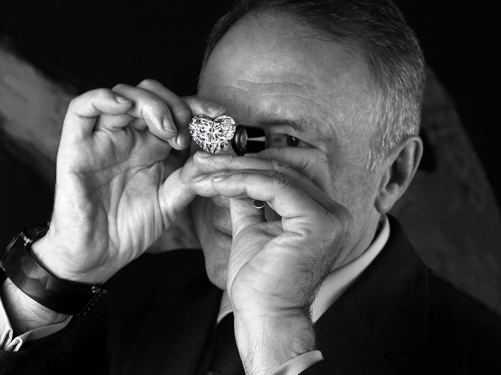 Way Laurence Graff studying a heart shaped diamond through a loupe 