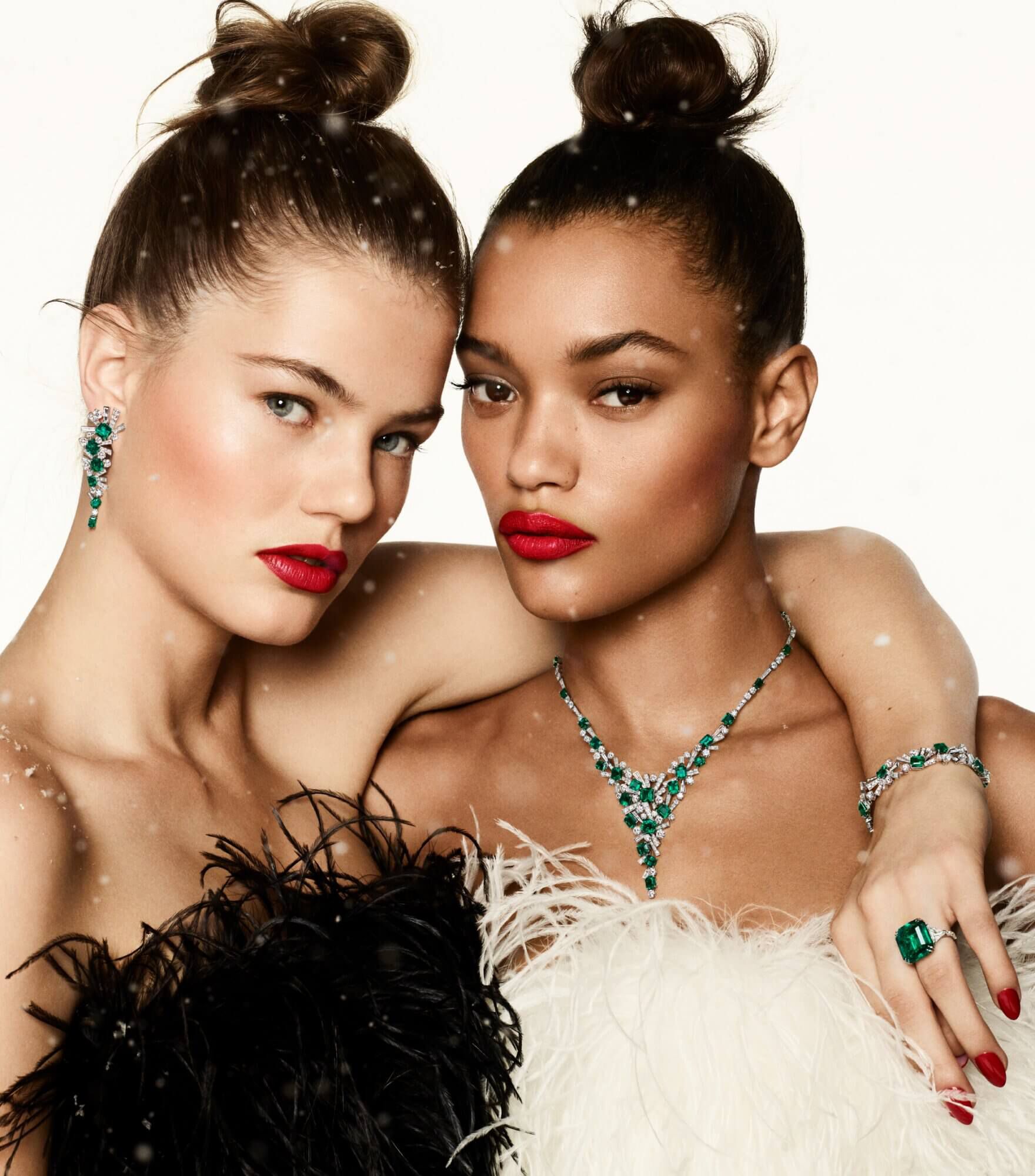 Two models wearing Graff emerald and white diamonds high jewellery
