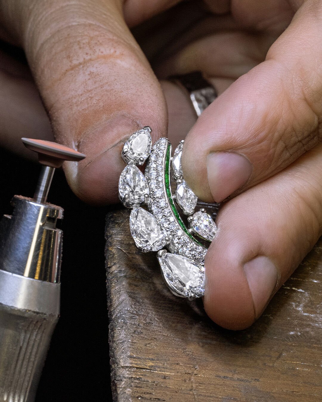Image shows Graff high jewellery white diamond and emerald earrings being created in Graff workshop