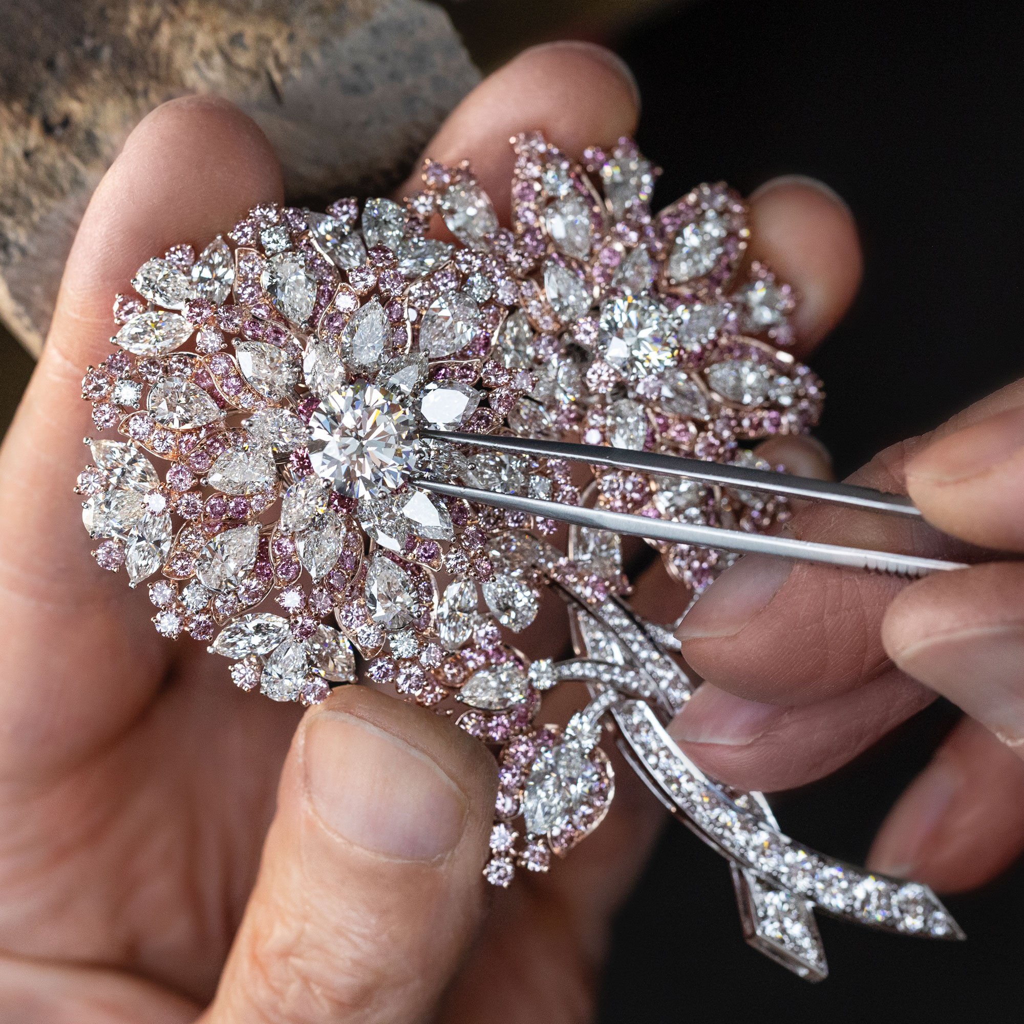 Close up of a Graff craftsman setting a pink and white diamond high jewellery brooch