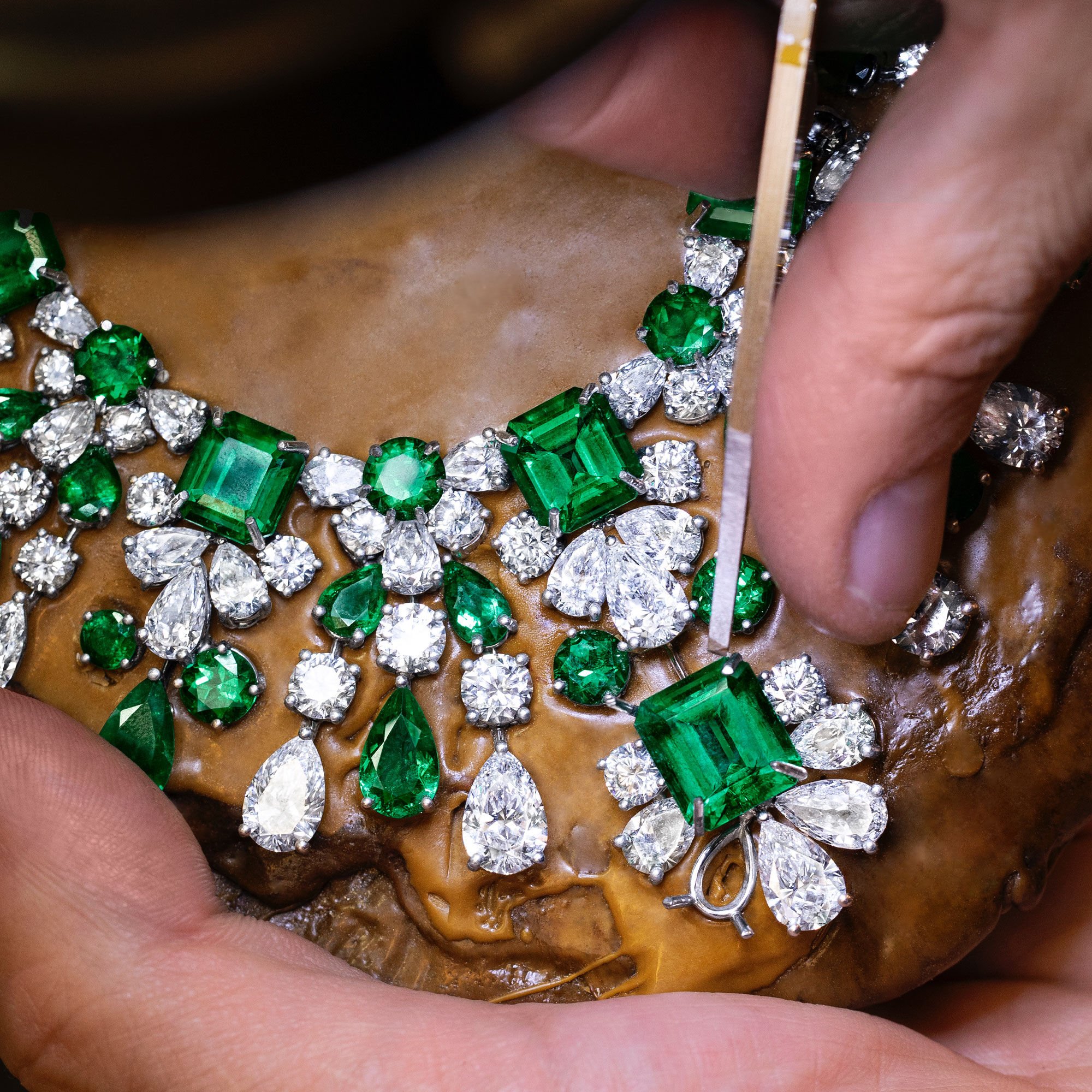 A Graff craftsman setting a emerald and diamond necklace in the workshop 
