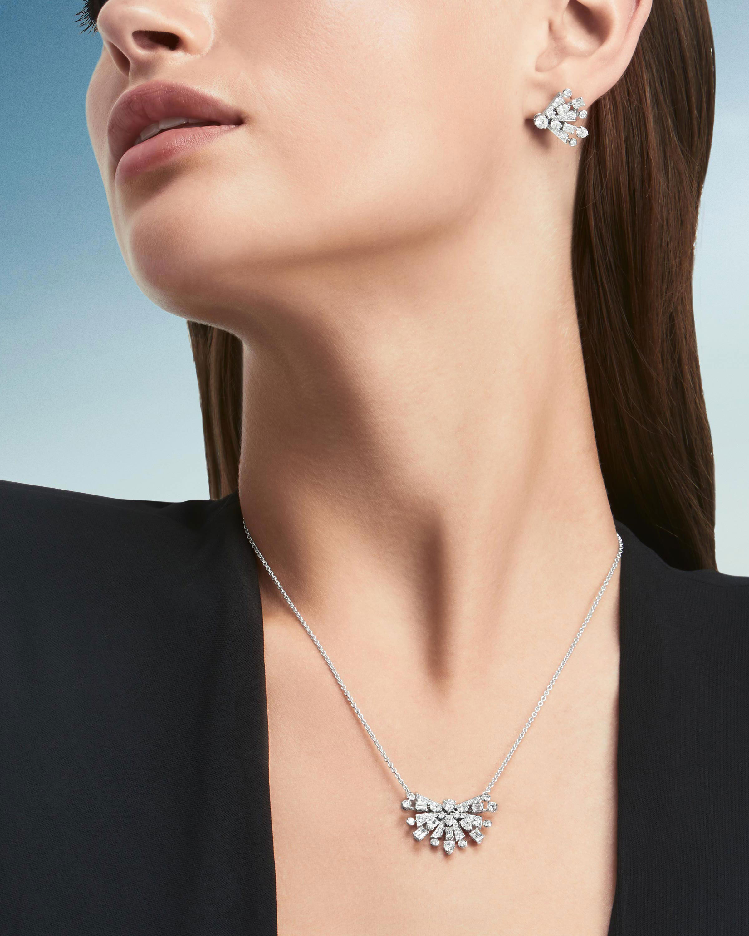 Close up of a model wearing the Graff New Dawn jewellery collection diamond earrings & pendant