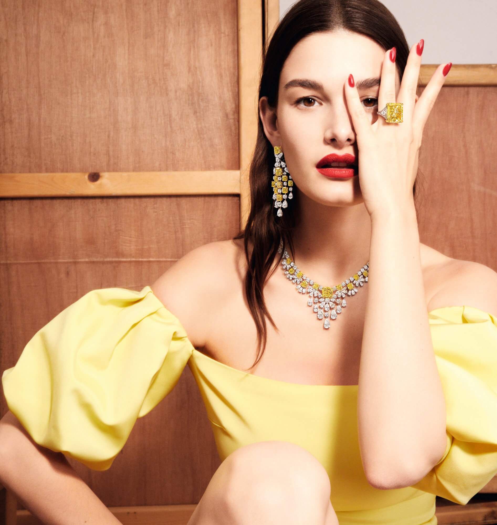 Model wears Graff yellow and white diamond high jewellery earrings and ring