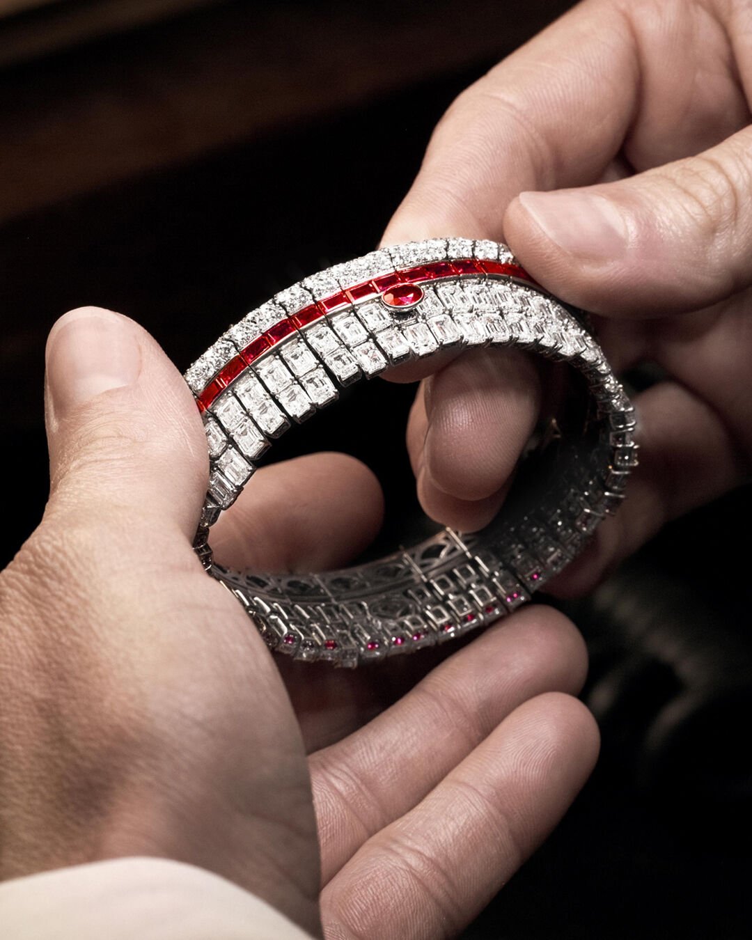 Graff craftsman holding Ruby and White Diamond High Jewellery bangle in Graff workshop