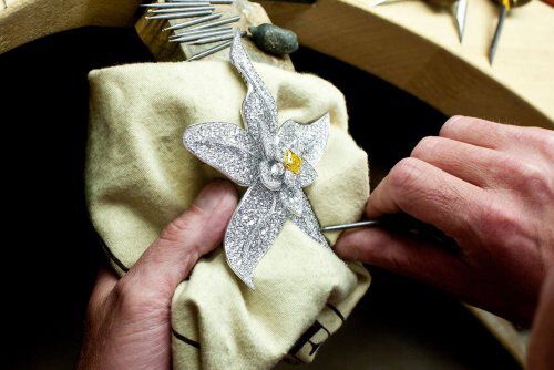 A diamond flower brooch in the hand of a graff craftsman