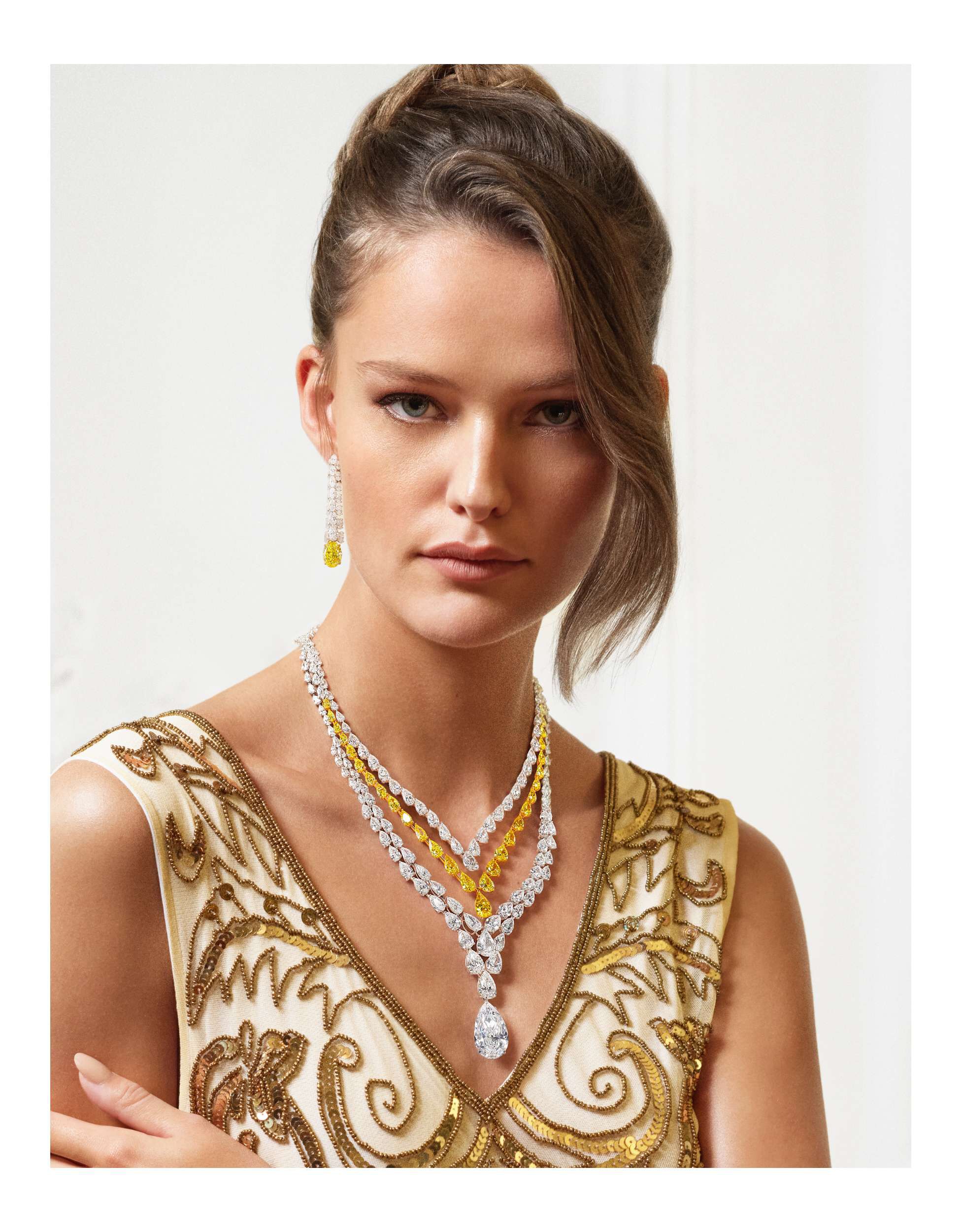 Close up of a woman wearing Graff high jewellery necklaces and earrings