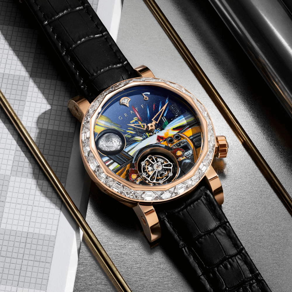 A Graff Men's GyroGraff Futuristic Drive watch with rose gold diamond bezel on a desk with stationeries