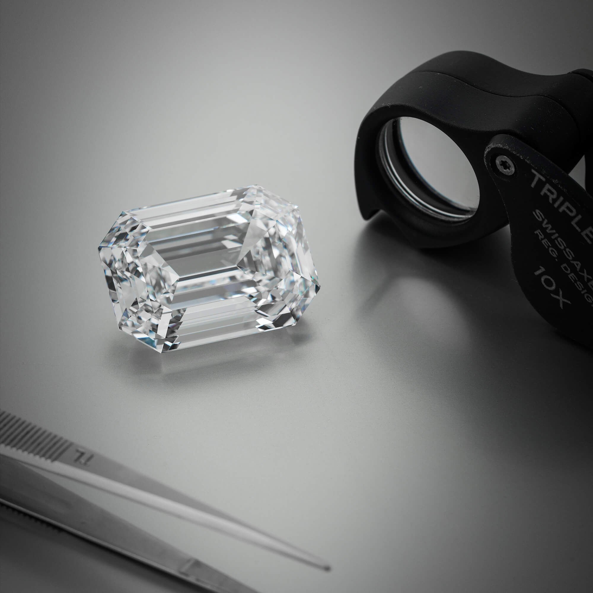 Graff Eternal Twins diamond in the workshop next to a loupe.