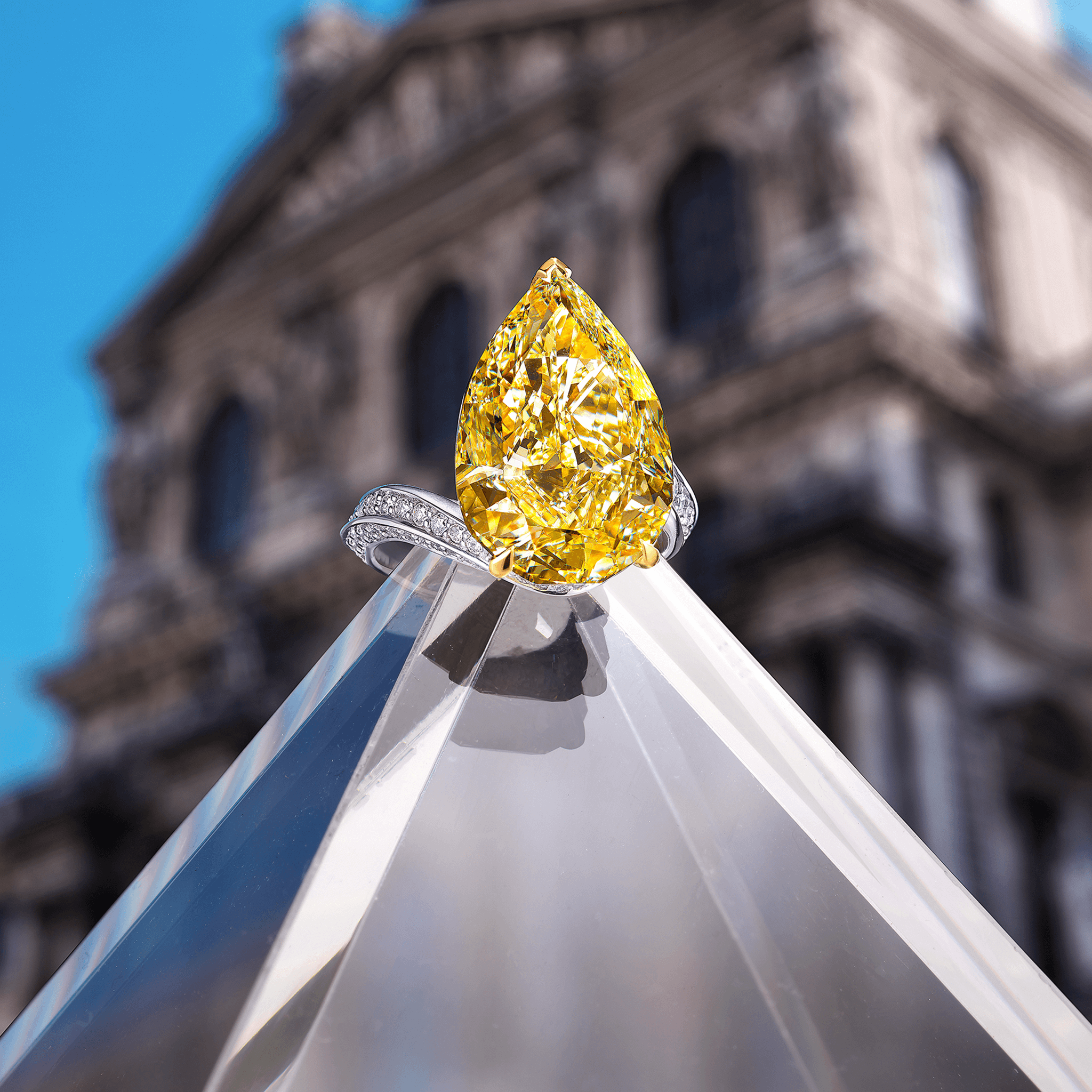 Graff Fancy Yellow Internally Flawless Pearshape Diamond High Jewellery Ring Set On A White Pave Twisted Band in front of a Gallery
