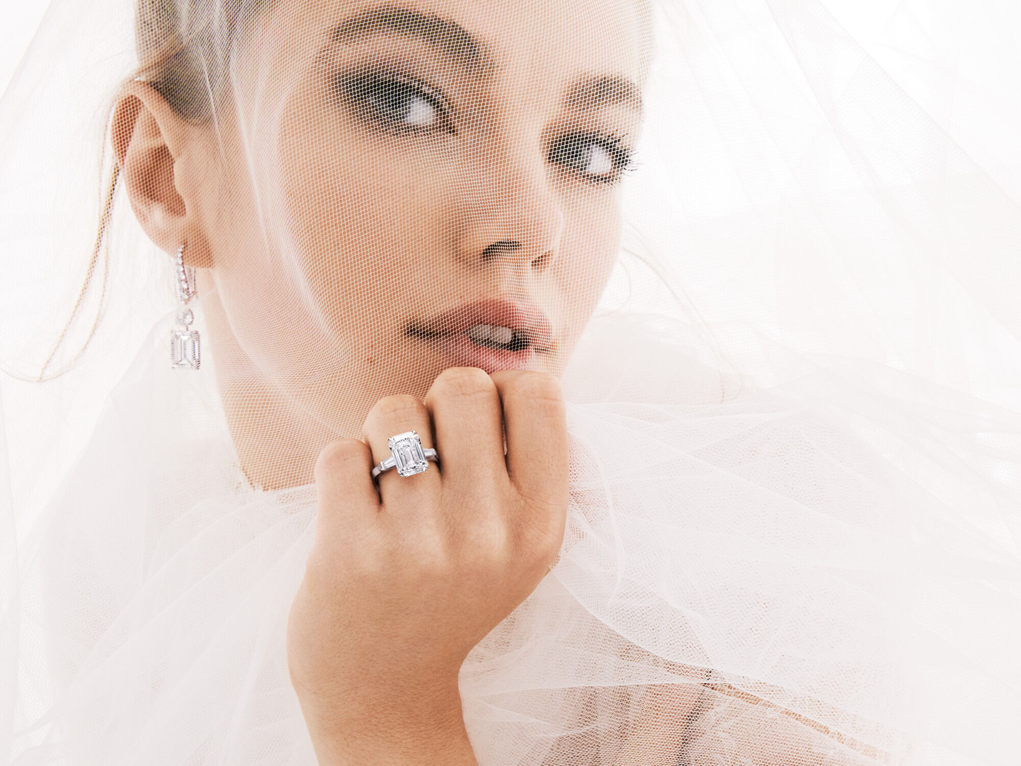 Bridal model wears Classic Graff solitaire earrings and Graff Promise Emerald Cut Engagement Ring