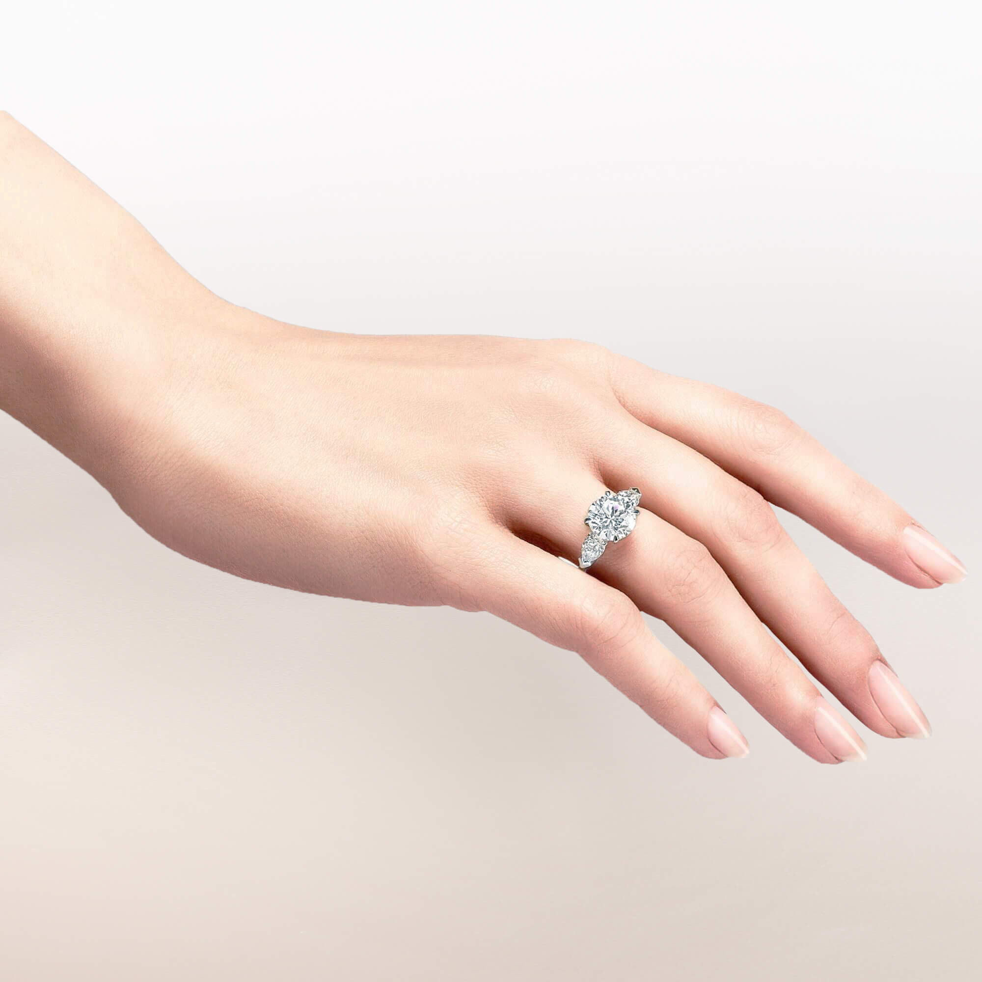 Close up of a Graff round diamond engagement ring wore by a model