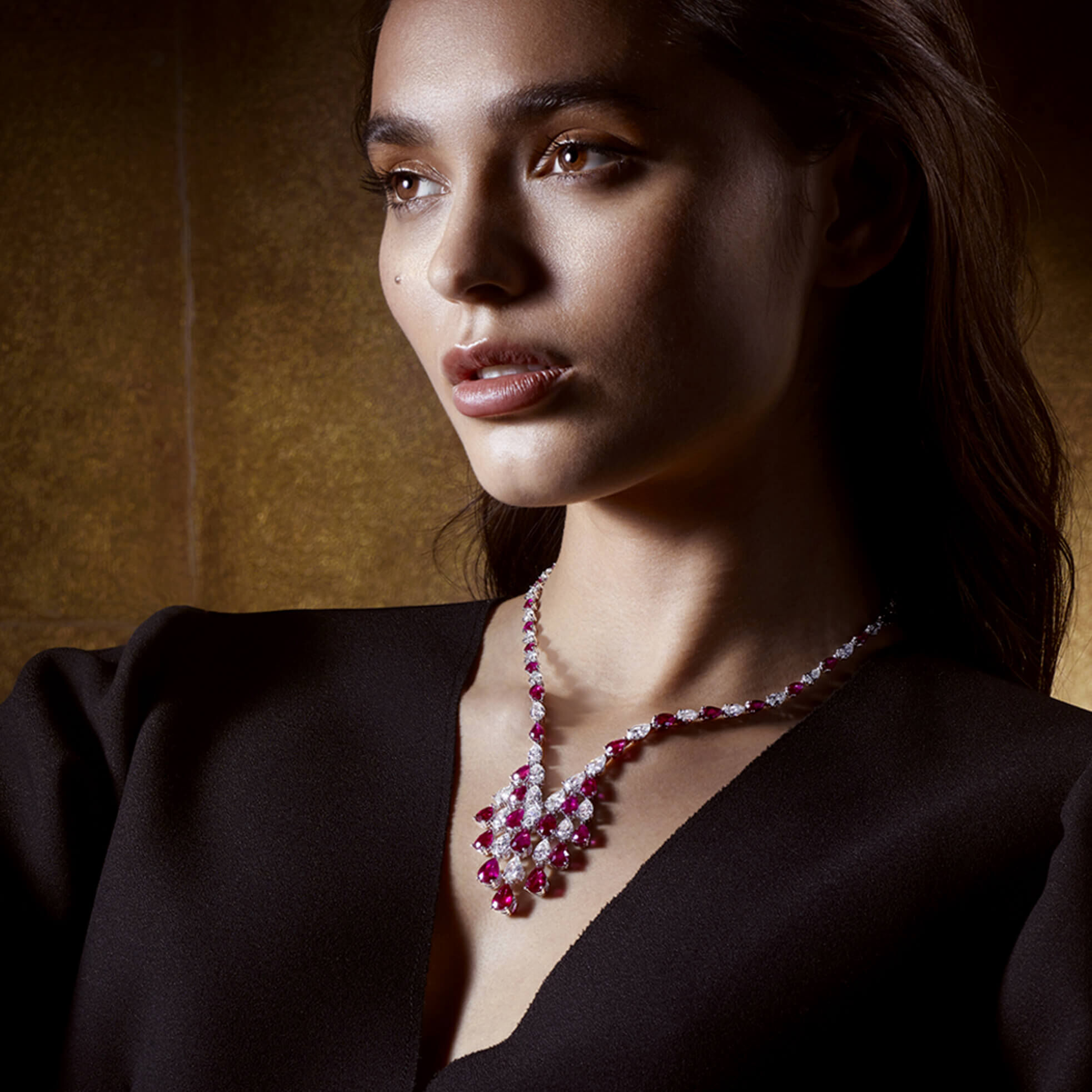 A lady wearing a Graff pear shape ruby and diamond necklace