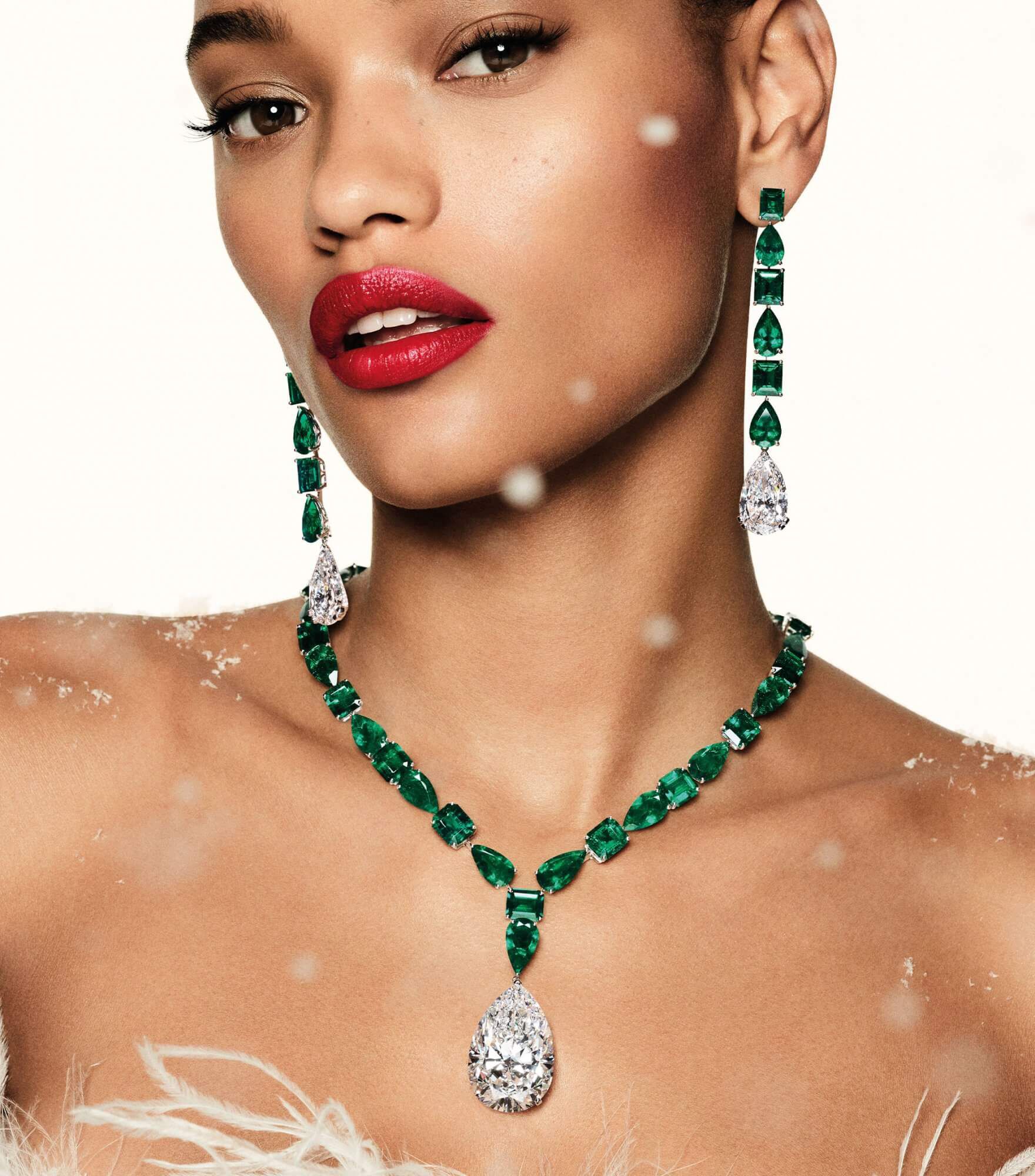 a lady wearing Graff emerald cabochon high jewellery necklace and earrings