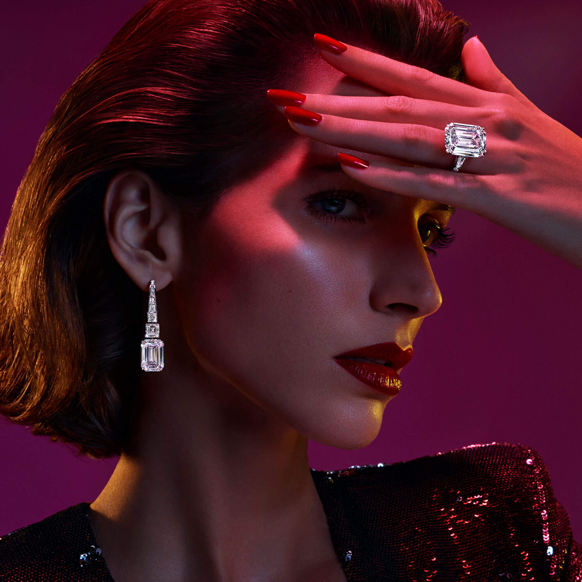 A model wears Graff high jewellery emerald cut diamond earrings and a D Flawless emerald cut diamond ring