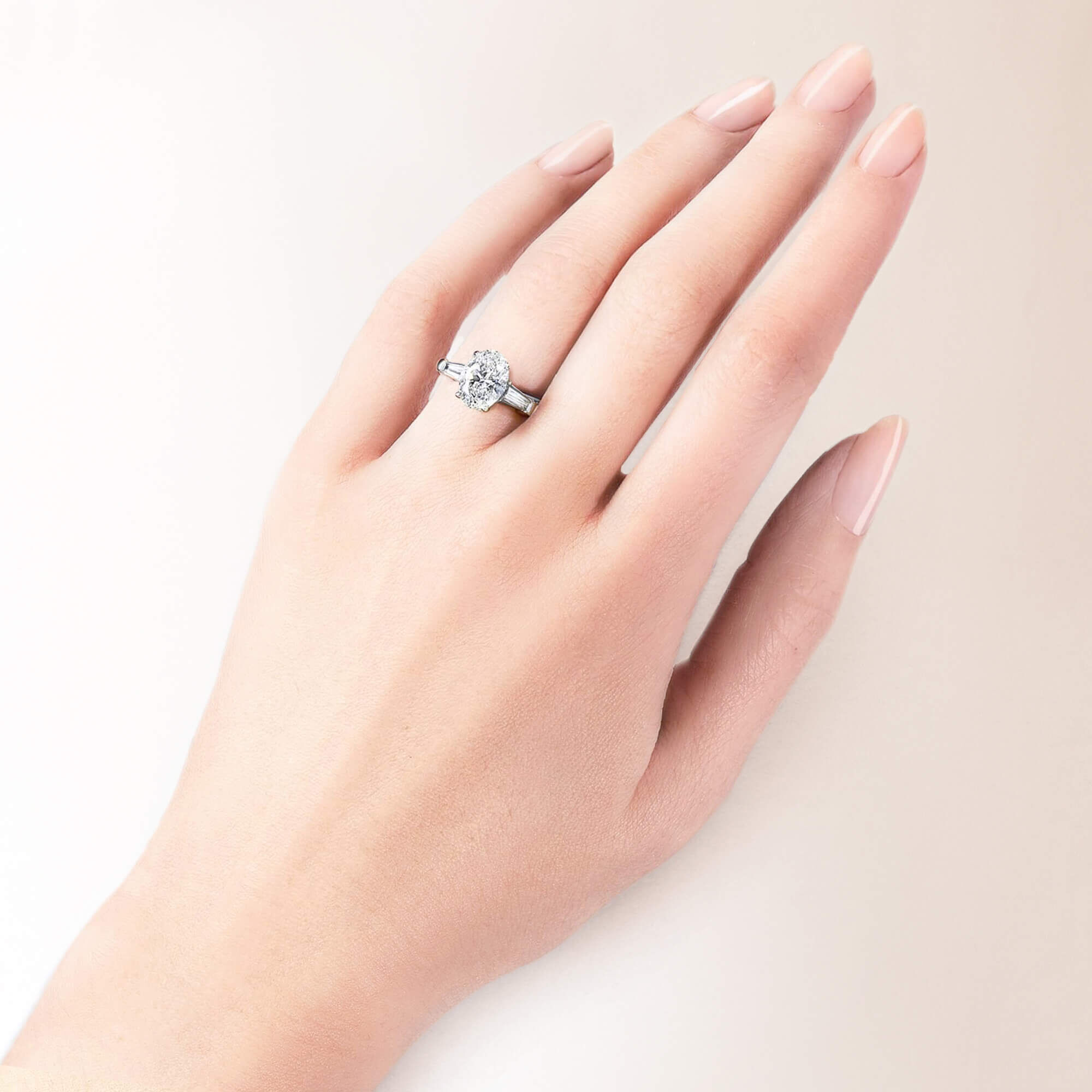A models hand wearing a Graff oval shape diamond engagement ring