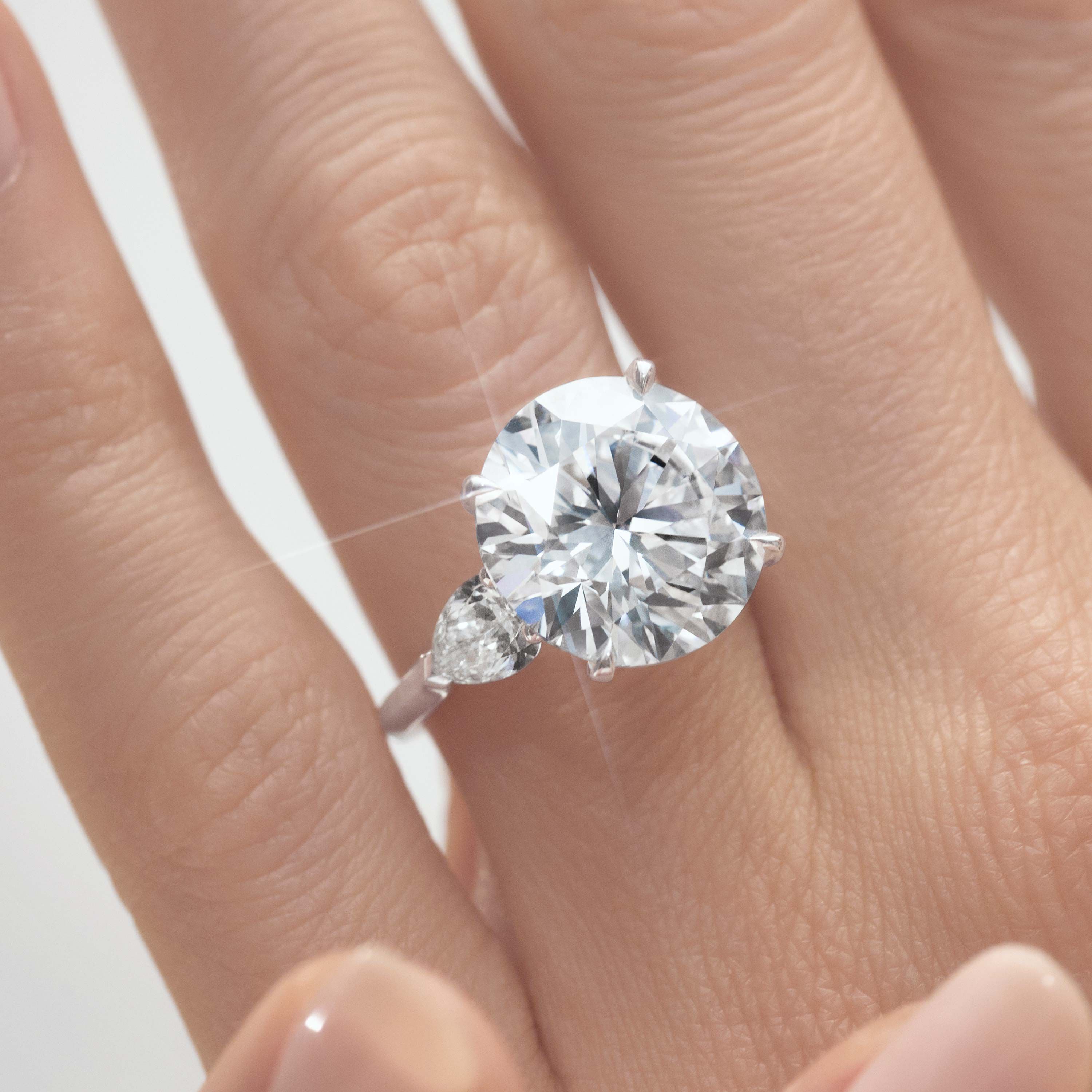 Close up of a Graff round diamond engagement ring wore by a model