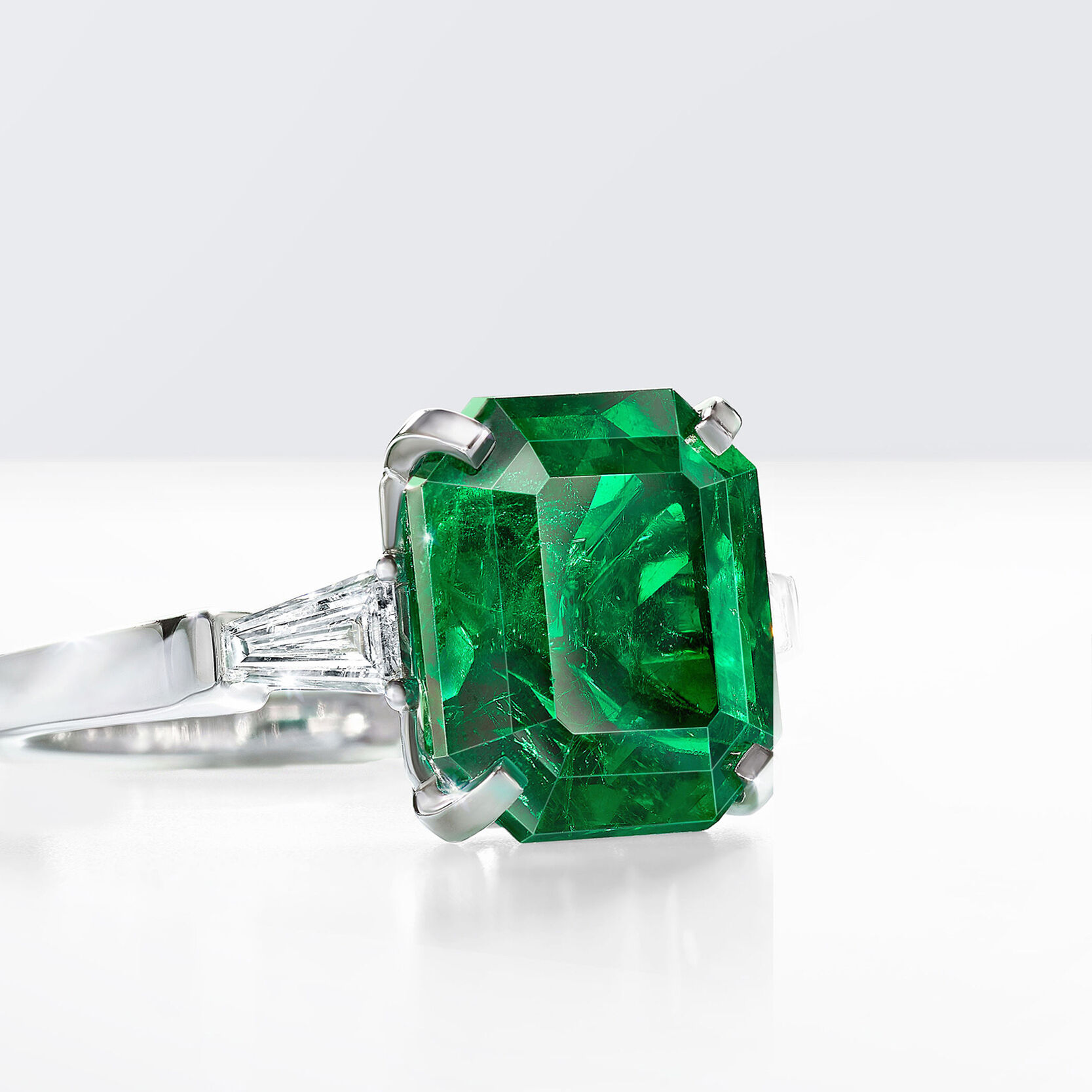 An emerald cut emerald ring with baguette cut side diamonds by Graff 