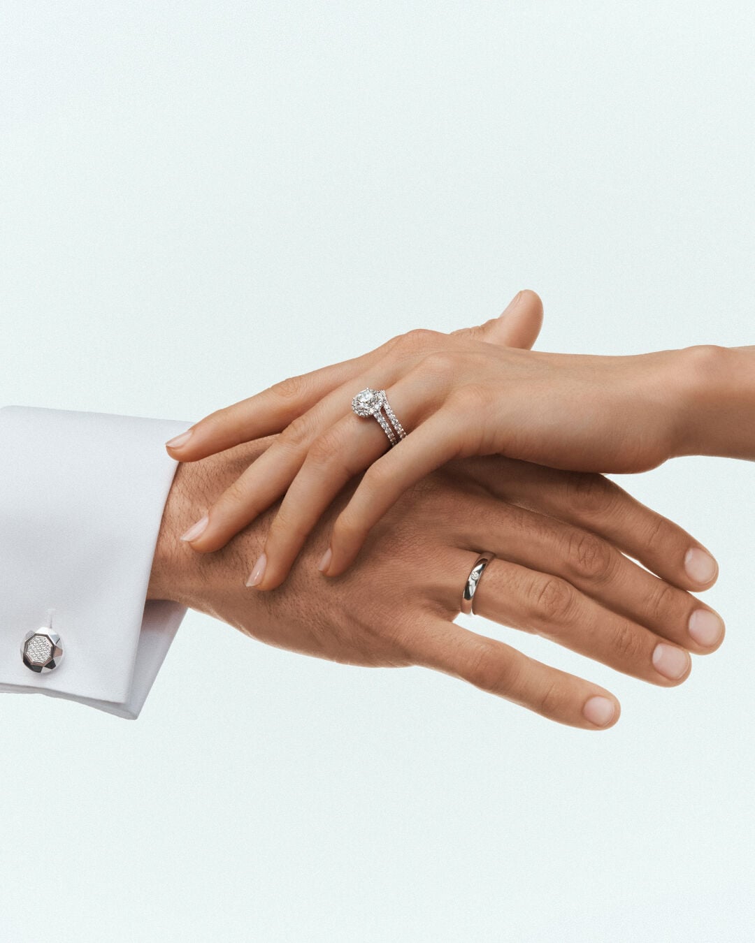 Image shows male and female hands wearing Graff Engagement Ring and Graff Wedding Band