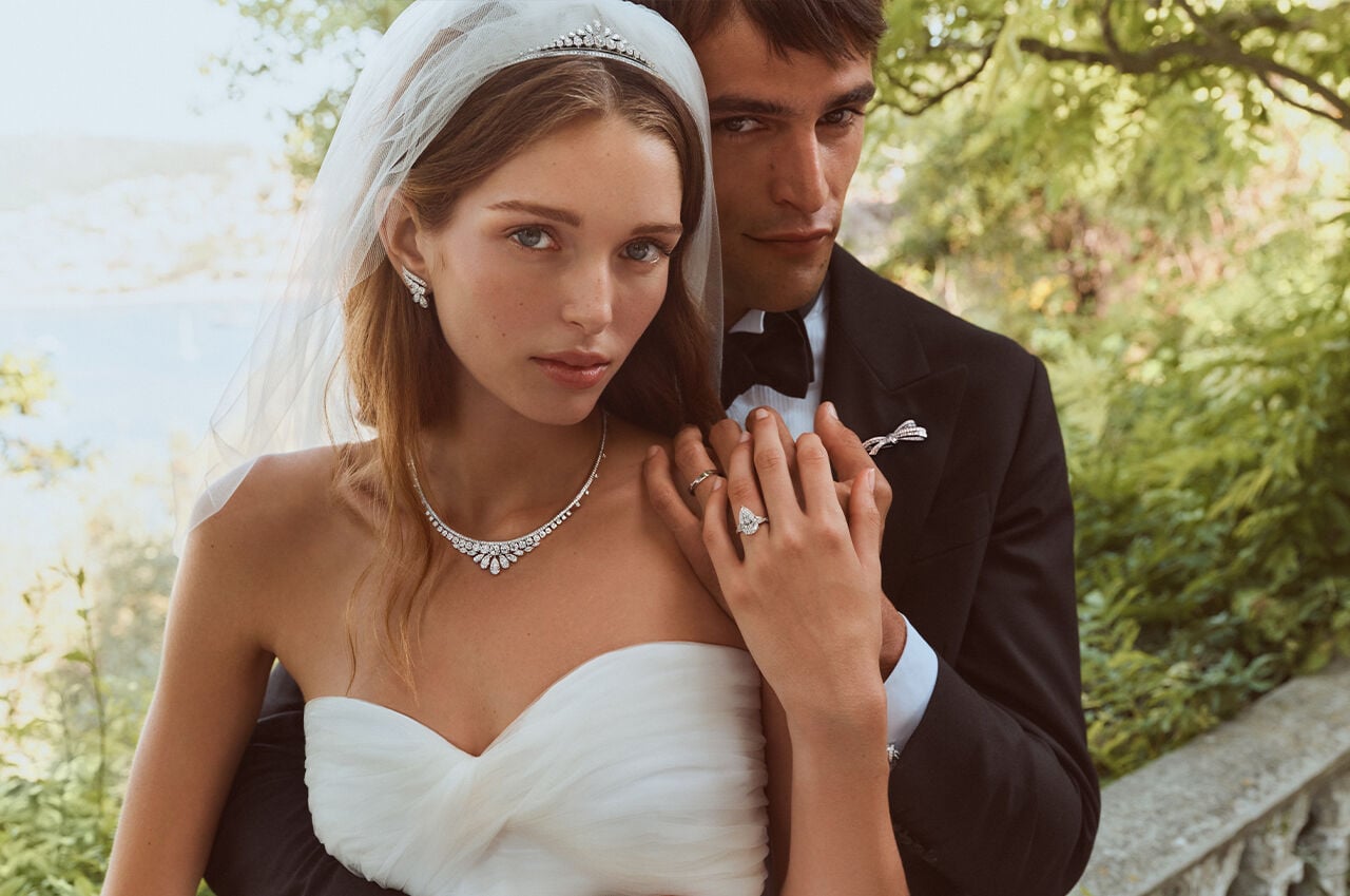 Image shows female and male model, posed as bride and groom wearing Graff jewellery