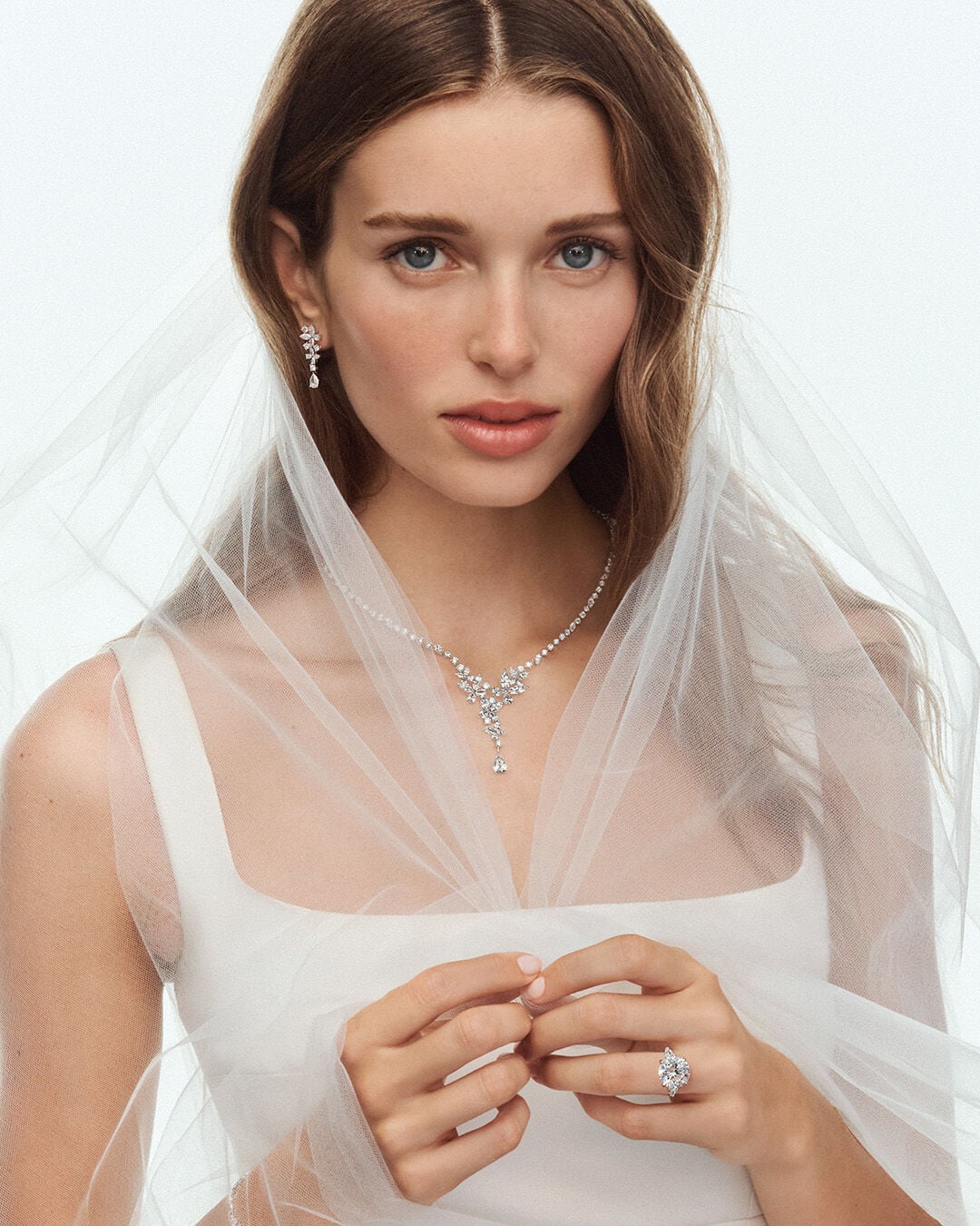 Image shows model wearing Graff Promise Round Diamond Cut engagement ring and Graff Butterfly diamond jewellery suite