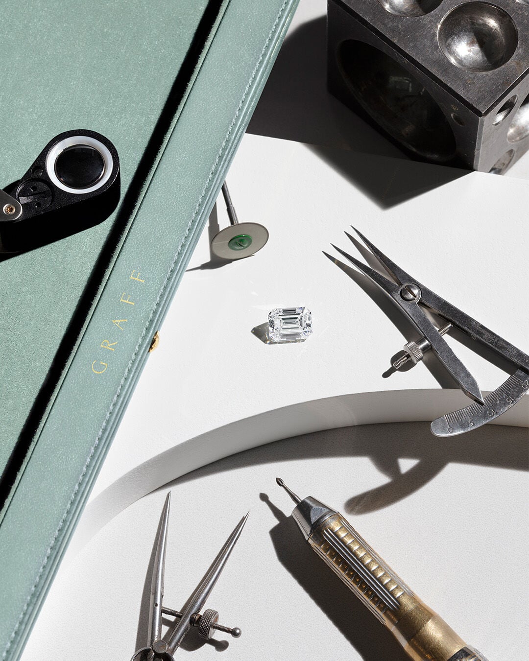 Image shows loose Graff Emerald Cut Diamond and tools