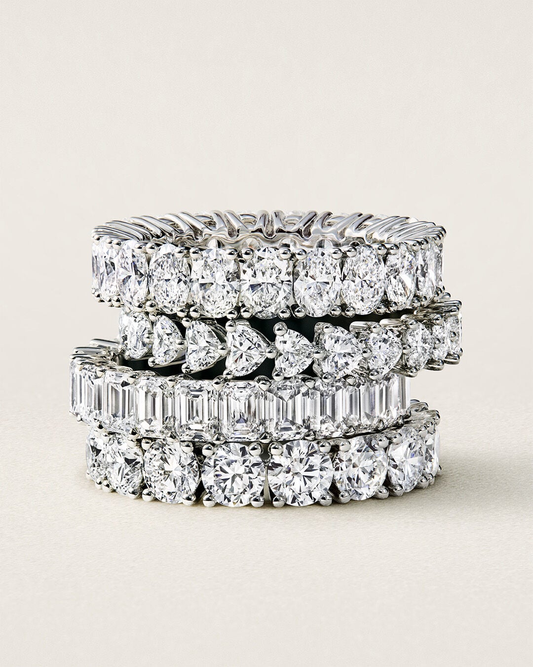 Image shows model hand wearing Graff Emerald Cut Promise diamond engagement ring and Emerald Cut diamond eternity ring