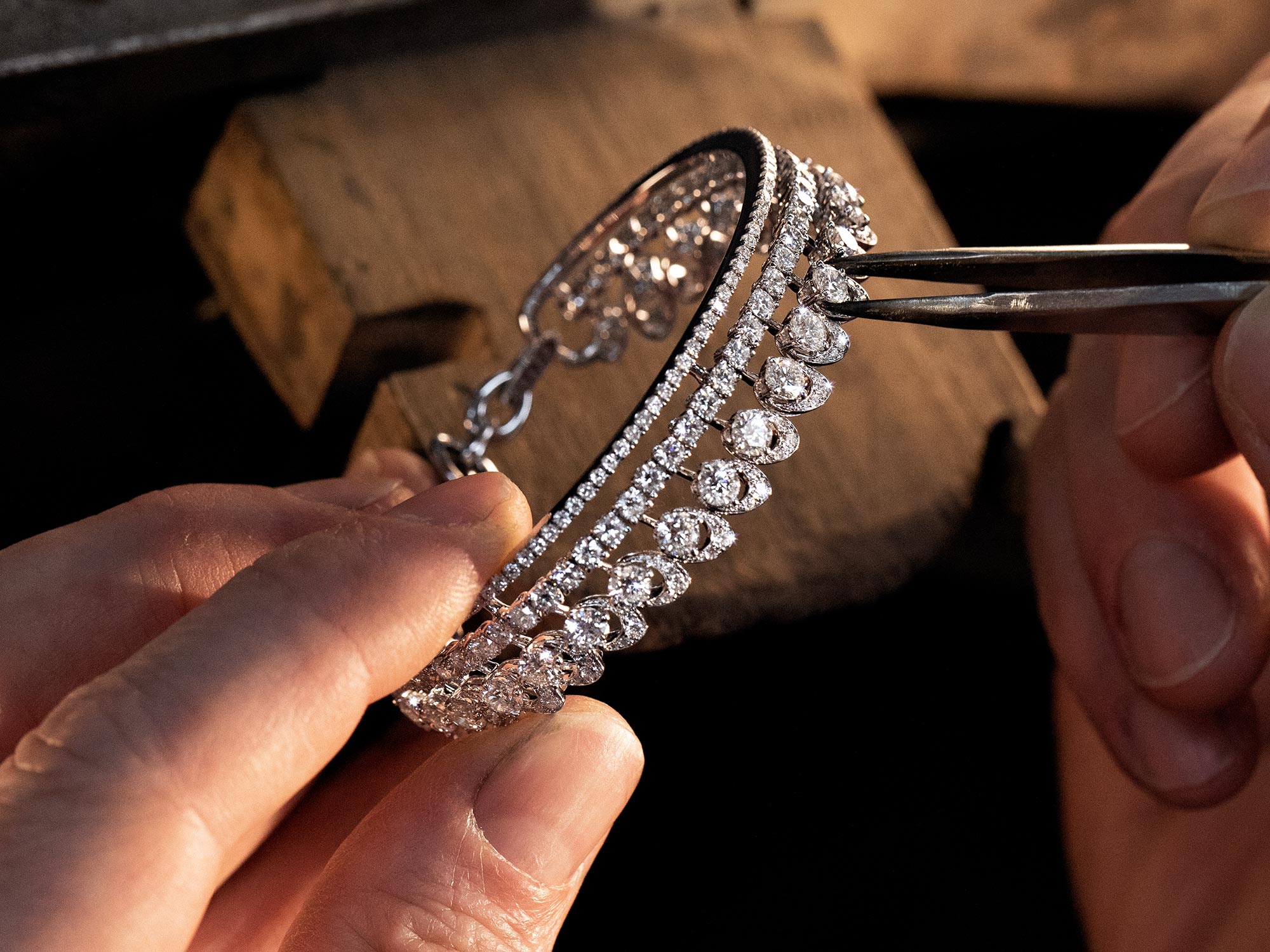 Close up of a Graff craftsman setting the diamonds of the a Gateway diamond bracelet from the Tribal jewellery collection in the workshop