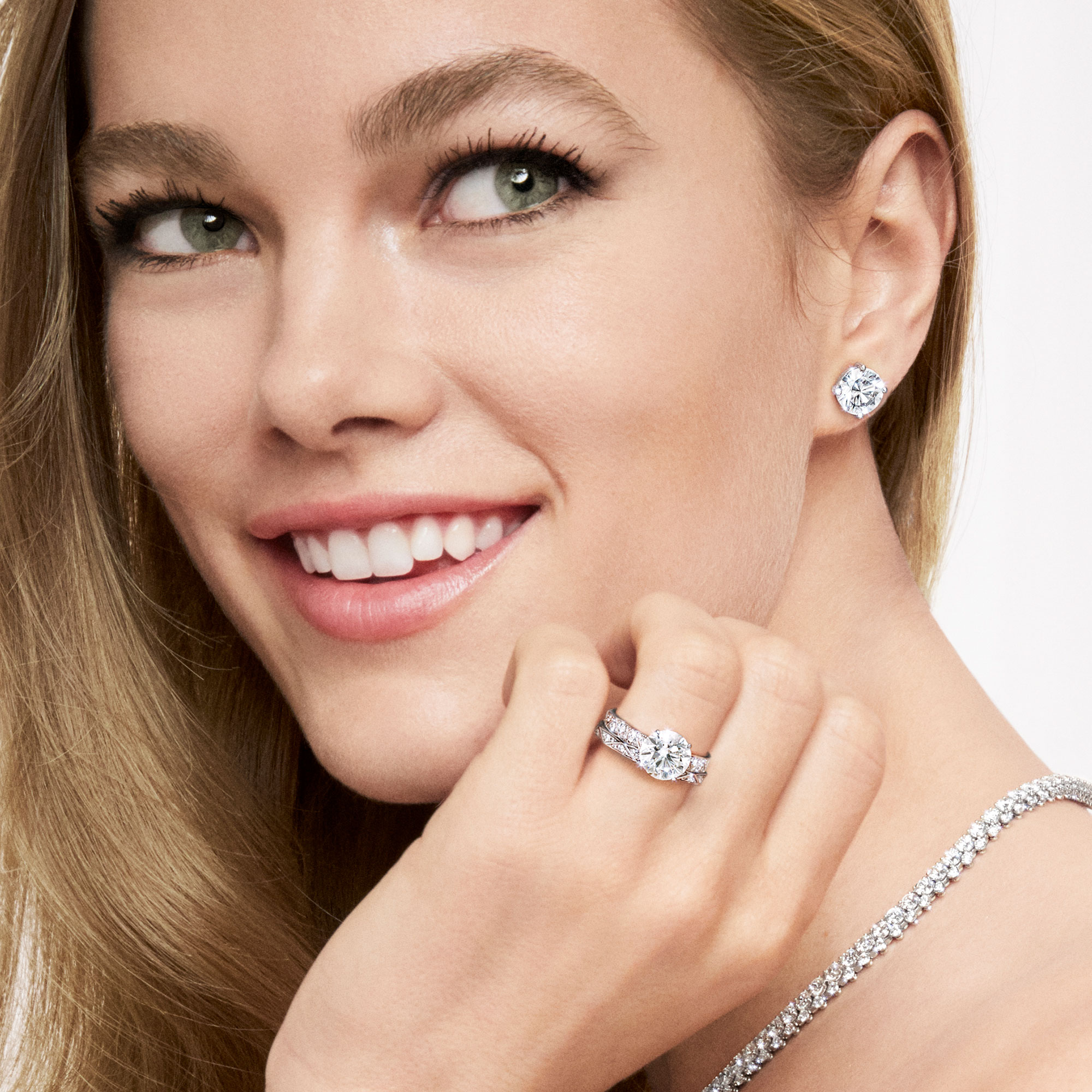 Model wearing Graff Round Diamond Stud Earrings and Laurence Graff Signature Round Diamond Engagement Ring and wessing band.