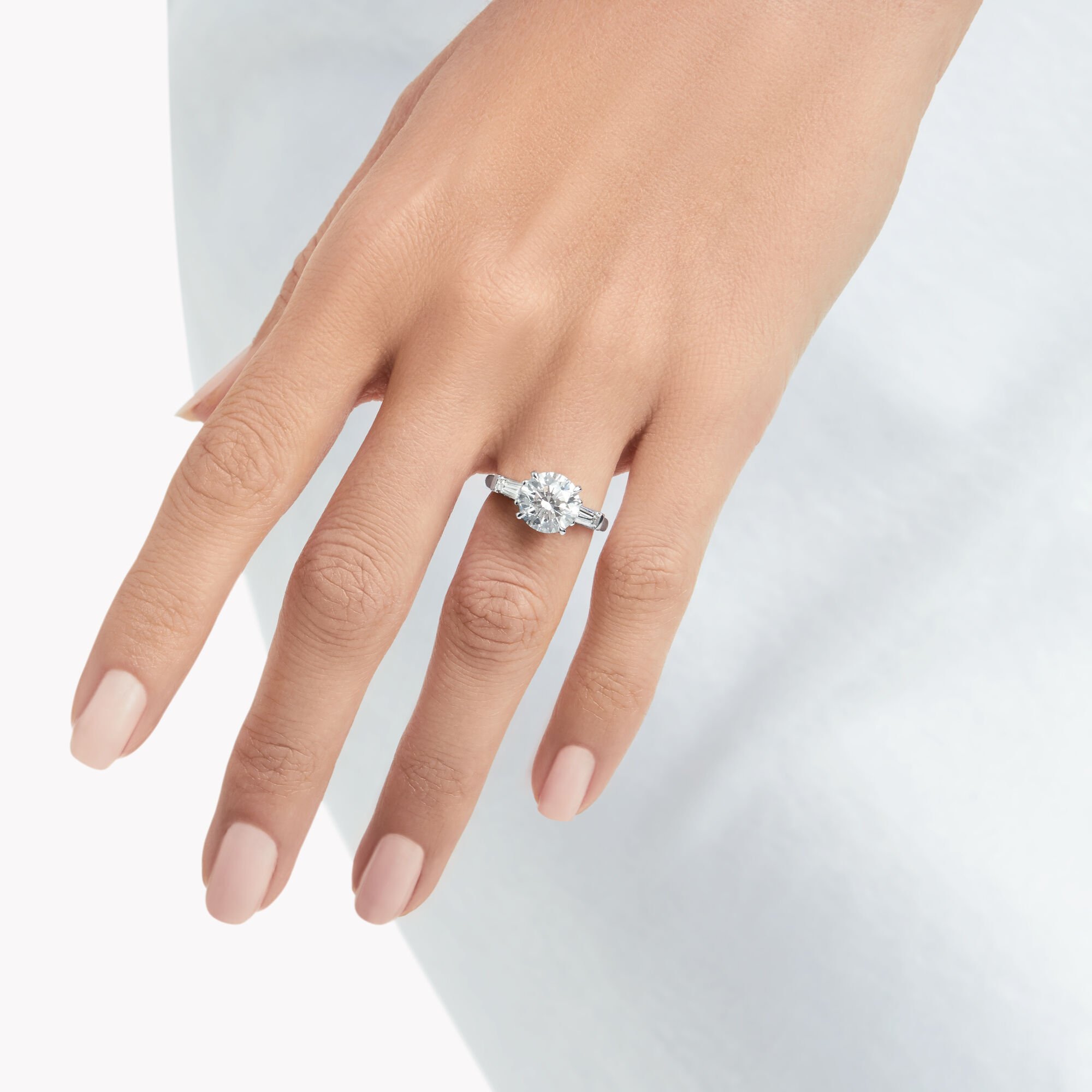 Model wears Promise Round Diamond Engagement Ring with baguette side stones from the Graff Bridal collection